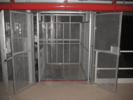 Magazijnlift uitgevoerd met blokkeringsklep voor veilig vervoer goederenkarren in een distributiecentrum - De Jong's Liften